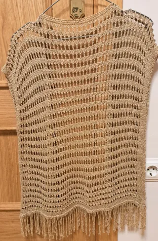 Chaleco de punto dorado con flecos