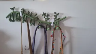 Colgador de pared verde con diseño de rama