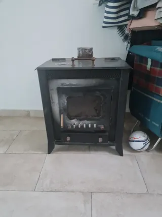 Estufa de leña metálica con puerta de cristal