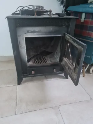 Estufa de leña metálica con puerta de cristal
