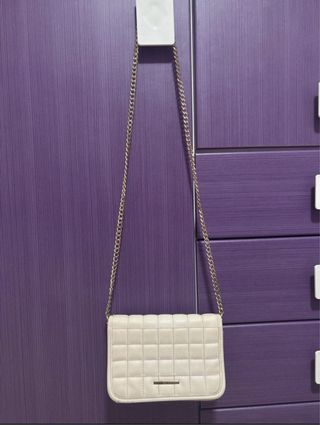 Bolso bandolera beige acolchado con cadena dorada