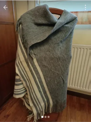 Poncho gris con flecos y rayas blancas