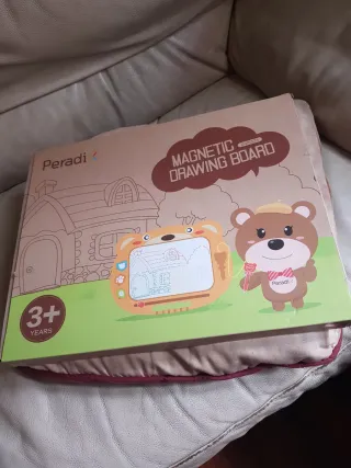 Pizarra magnética infantil con imágenes y puntero.