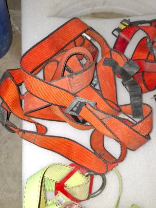 Arneses de seguridad naranjas y verdes