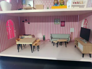 Casa de muñecas rosa con muebles.