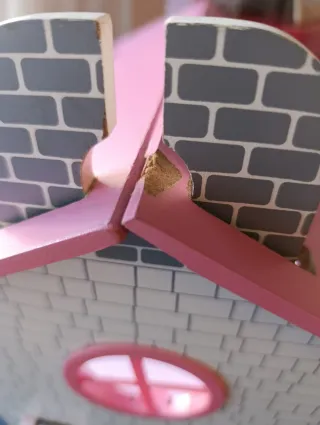 Casa de muñecas rosa con muebles.