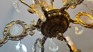 Lámpara de araña antigua de bronce con cristales.