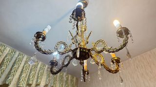 Lámpara de araña antigua de bronce con cristales.