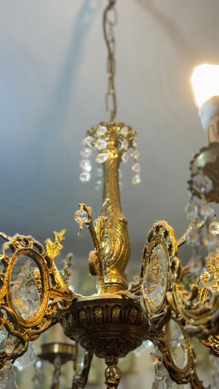 Lámpara de araña antigua de bronce con cristales.