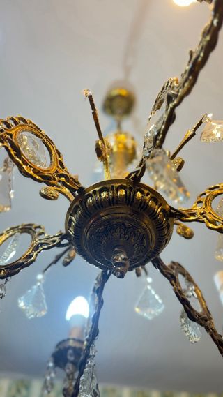 Lámpara de araña antigua de bronce con cristales.