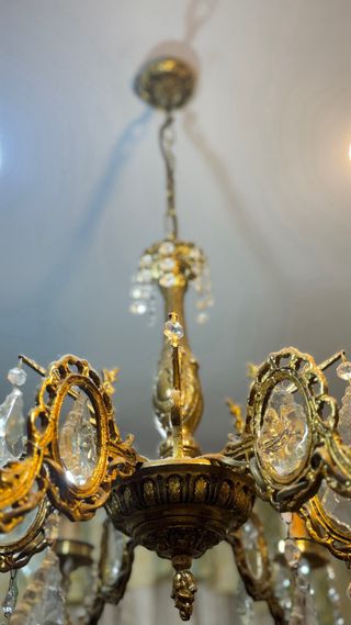 Lámpara de araña antigua de bronce con cristales.