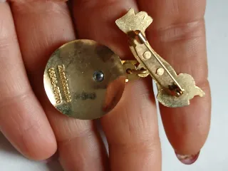 Spilla oro e rossa con nastro