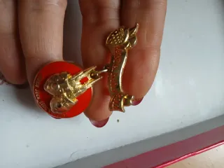 Spilla oro e rossa con nastro