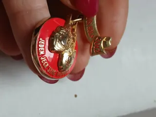 Spilla oro e rossa con nastro