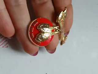 Spilla oro e rossa con nastro