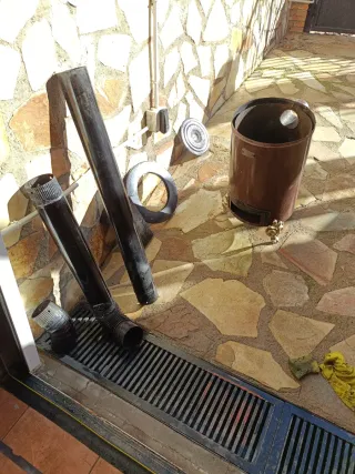 Estufa redonda metálica negra con tubos