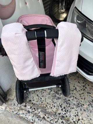 Cochecito de bebé rosa con plástico protector