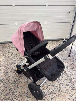 Cochecito de bebé rosa con plástico protector