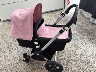 Cochecito de bebé rosa con plástico protector