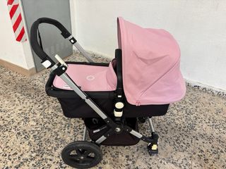 Cochecito de bebé rosa con plástico protector