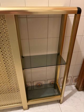 Cubre radiador metálico dorado.