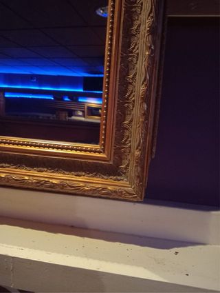 Espejo vintage con marco dorado.