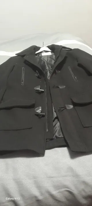 Abrigo negro con cremallera y botones