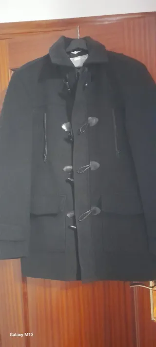 Abrigo negro con cremallera y botones