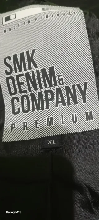 Abrigo negro con cremallera y botones