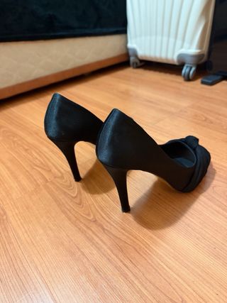 Tacones negros peep toe con diseño.