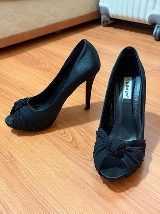 Tacones negros peep toe con diseño.