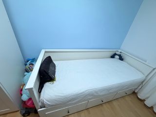 Cama blanca con cajones.