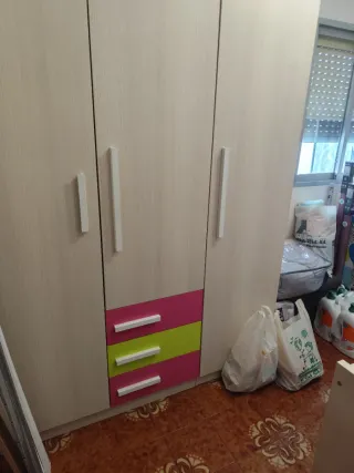 Armario beige con cajones verdes y rosas