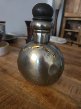 Botella antigua metálica con tapón de madera