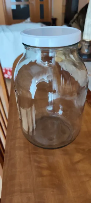 Bote de cristal grande con tapa blanca .