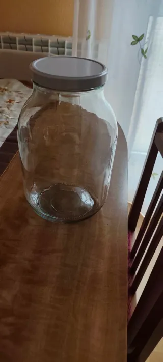 Bote de cristal grande con tapa blanca .