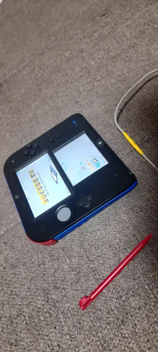 Nintendo 2DS nero, blu e rosso con caricatore e stilo