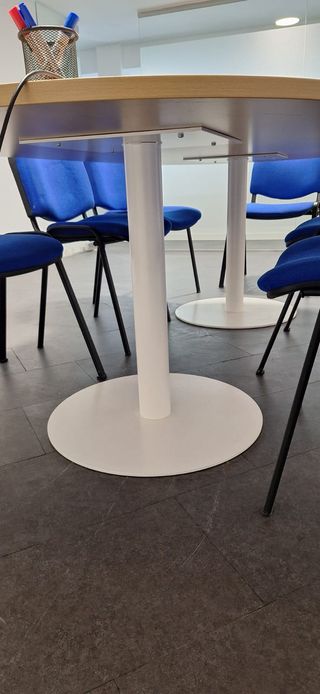 Sillas de oficina azules y mesa para reuniones