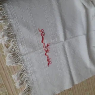 Asciugamani singolo con ricamo in rosso e frange.