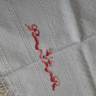 Asciugamani singolo con ricamo in rosso e frange.