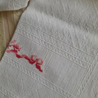 Asciugamani singolo con ricamo in rosso e frange.