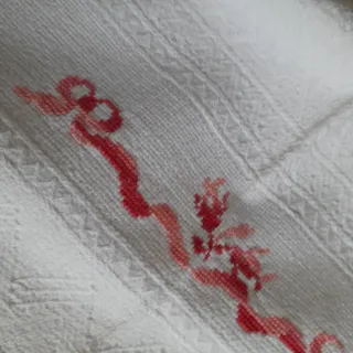 Asciugamani singolo con ricamo in rosso e frange.