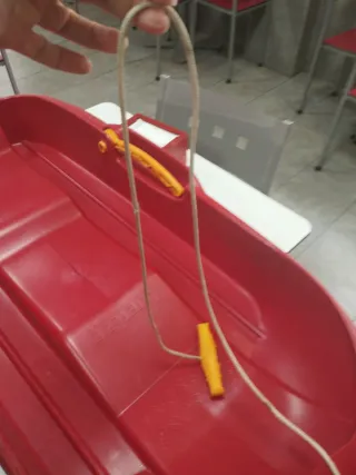 Trineo rojo y pala de nieve azul