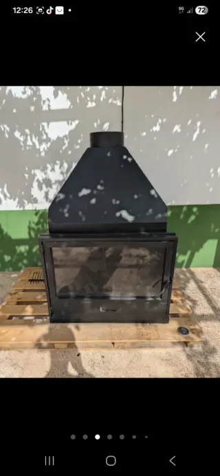 Estufa de leña metálica con puerta de cristal