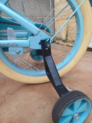Bicicleta niña azul con cesta y ruedines.