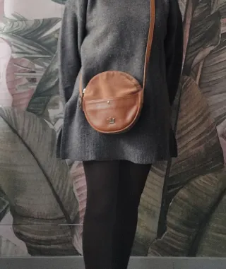 Bolso bandolera de piel redondo color cuero.