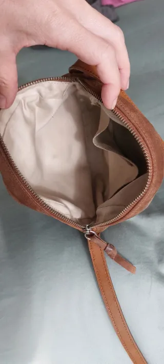 Bolso bandolera de piel redondo color cuero.