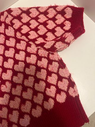 Maglioncino con cuoricini rosa su sfondo rosso