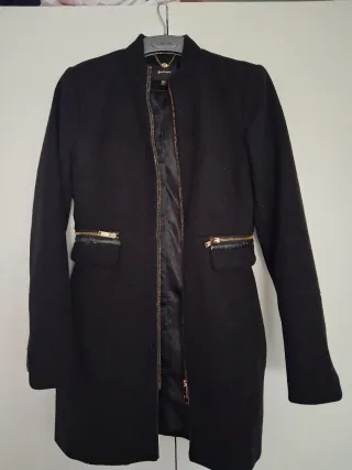 Abrigo negro con cremalleras doradas