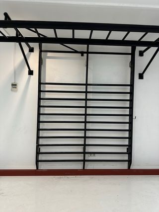 Espaldera negra con soporte de dominadas